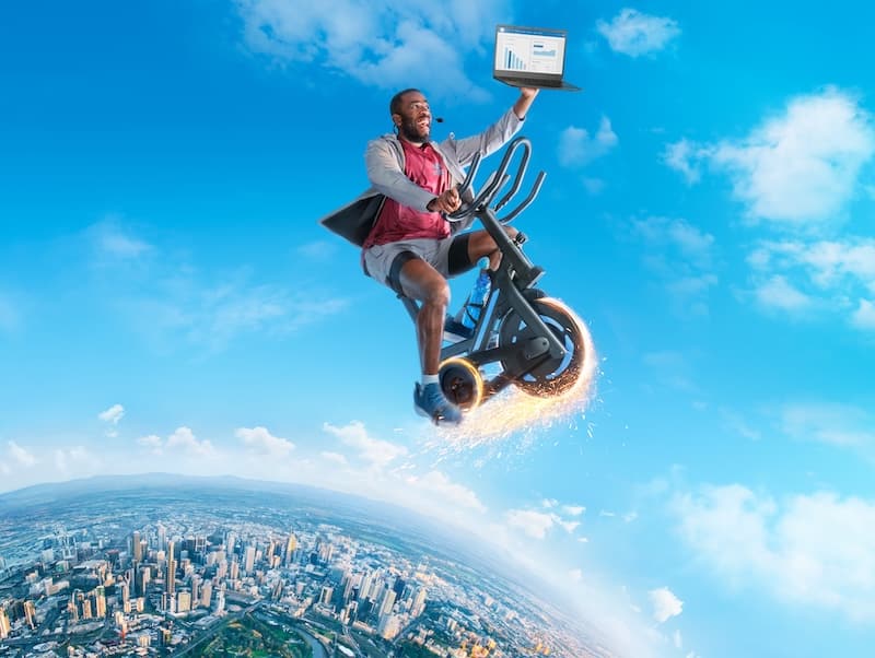 Person flying on a bike holding up a laptop with Xero’s accounting software supercharging their business