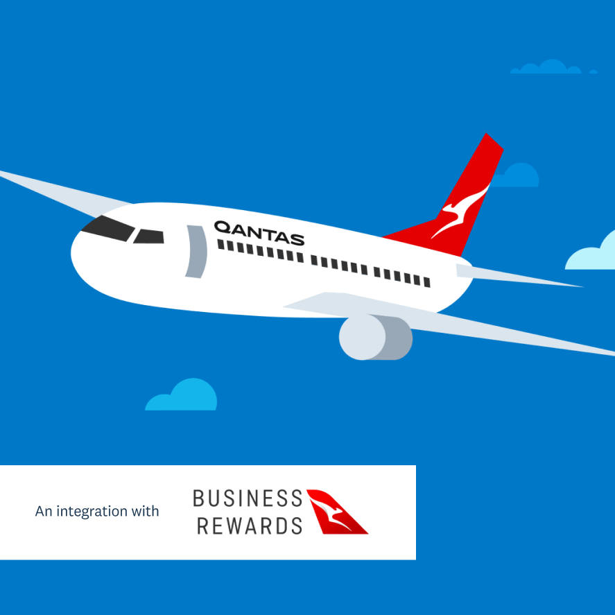 A Qantas aeroplane flies in a blue sky.