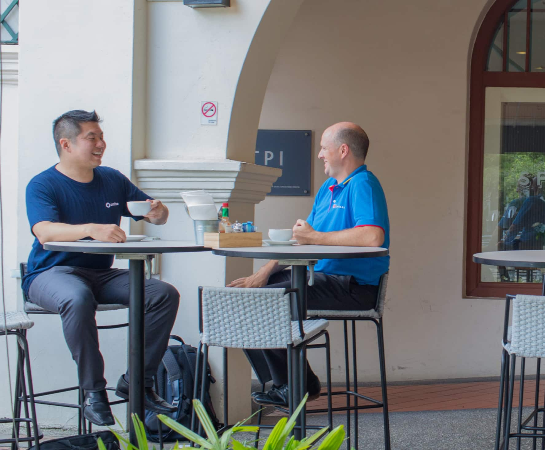 Picture of two men sitting a bar table at a food & beverage establishment