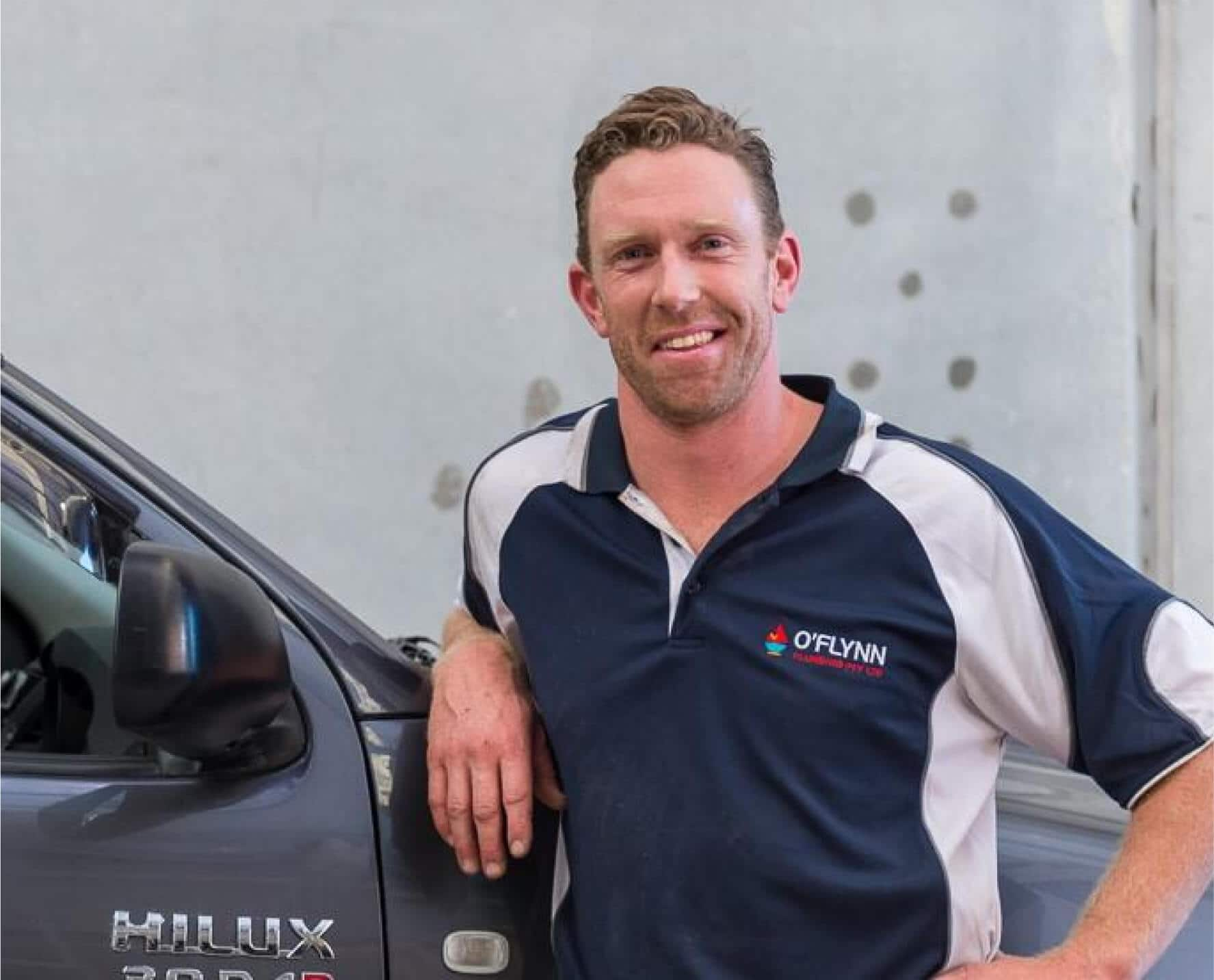 A plumber standing in front of a utility vehicle