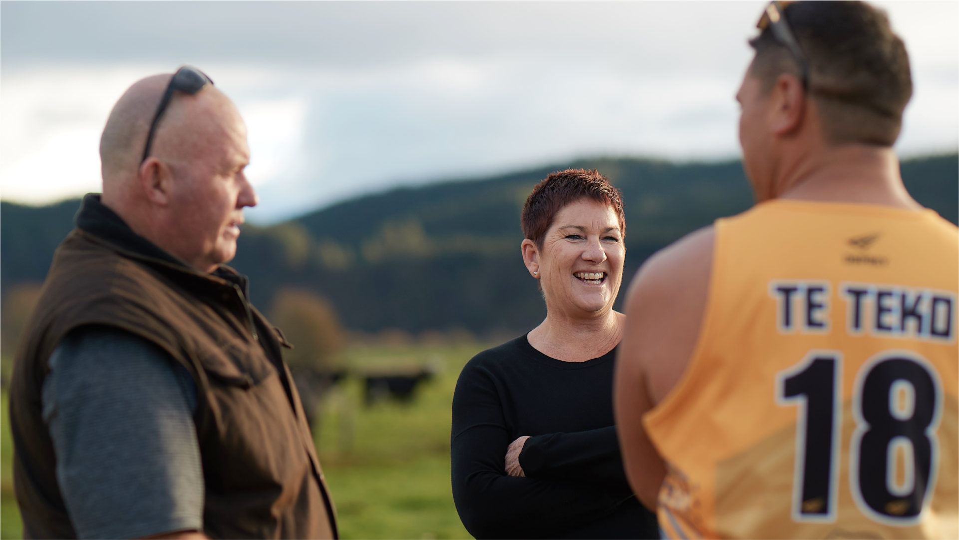 Three farmers speaking in a paddock