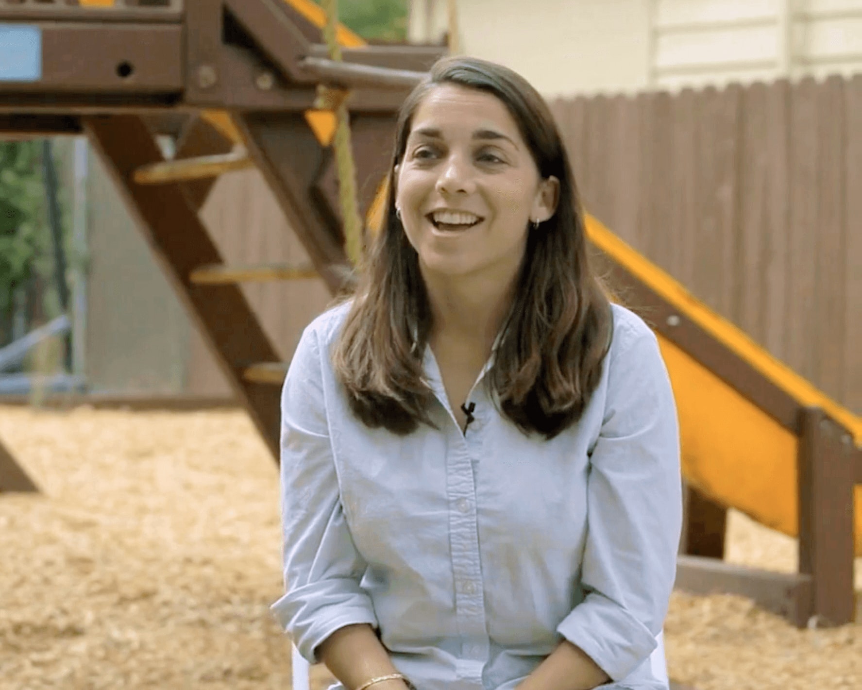 Portrait of a person being interviewed at a school playground.