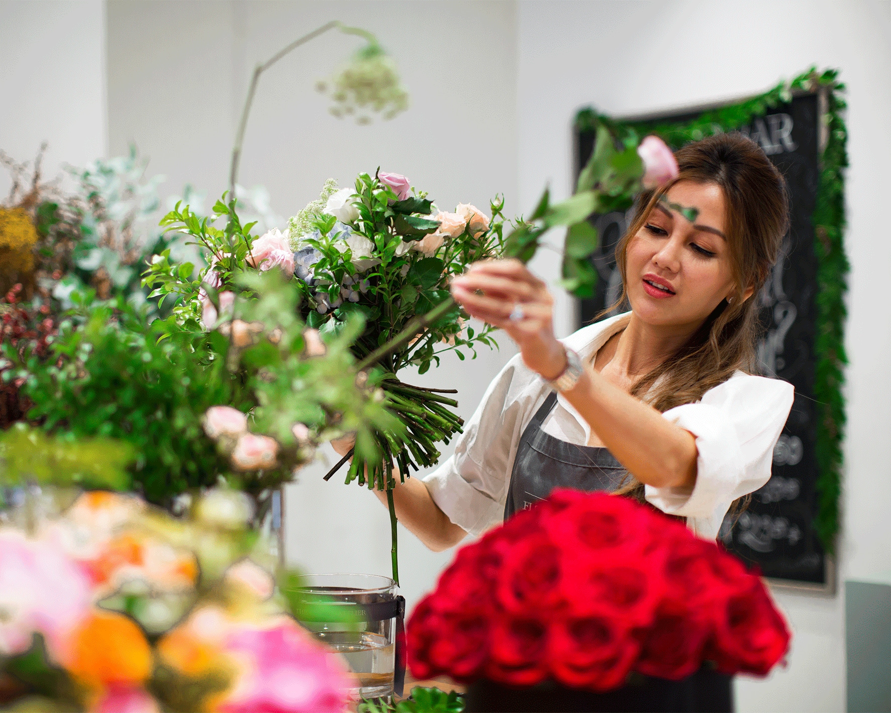 A person arranging flowers in a store.