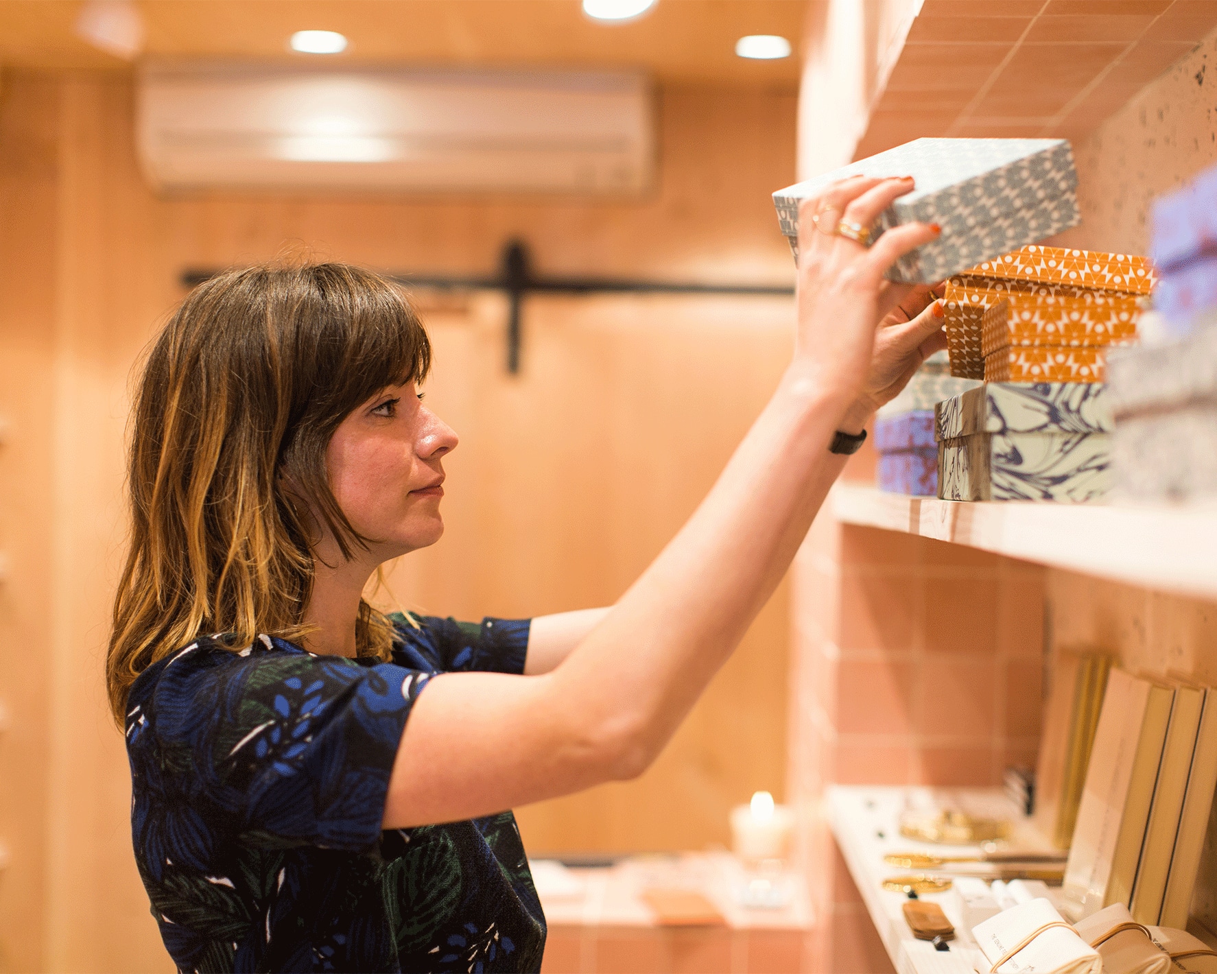 A person organizing boxes in a retail store.