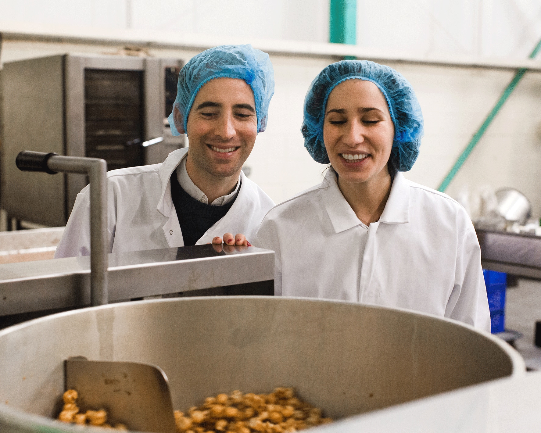 Two people making popcorn in a factory.