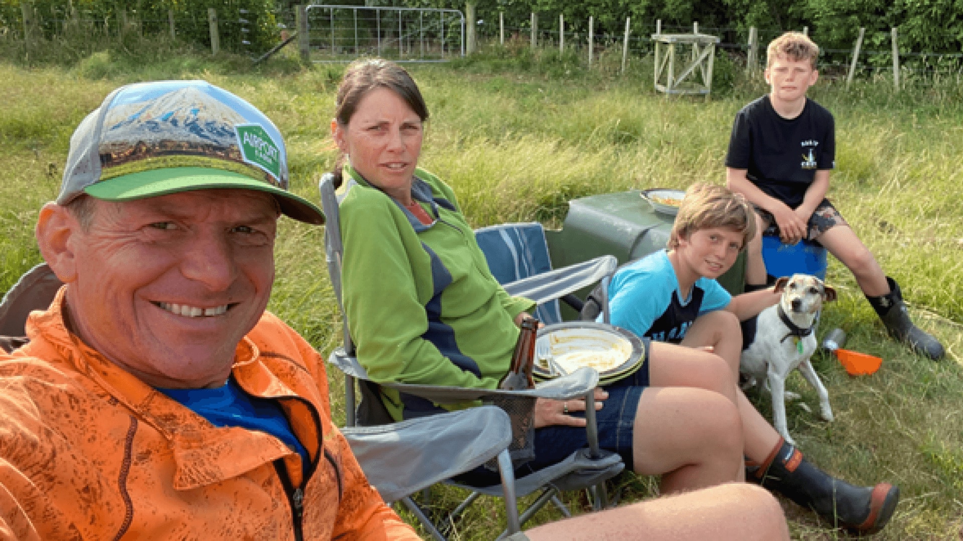 Two farmers and their children relax over lunch on the farm.