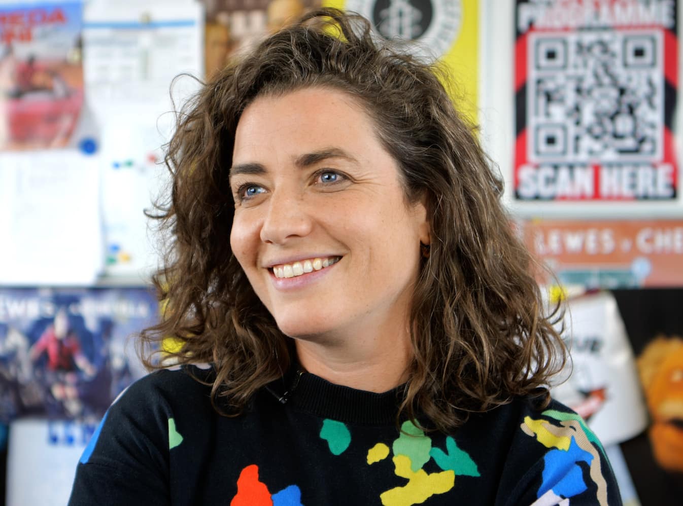 Portrait of Maggie Murphy, in front of football club posters.