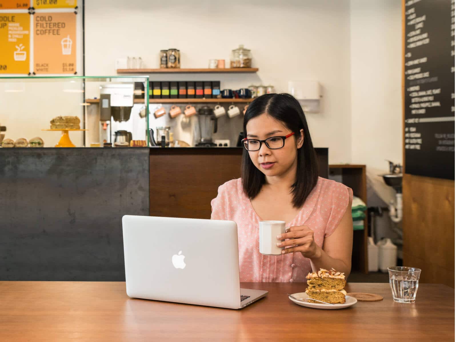 An accountant works on client workpapers at their laptop in a cafe.