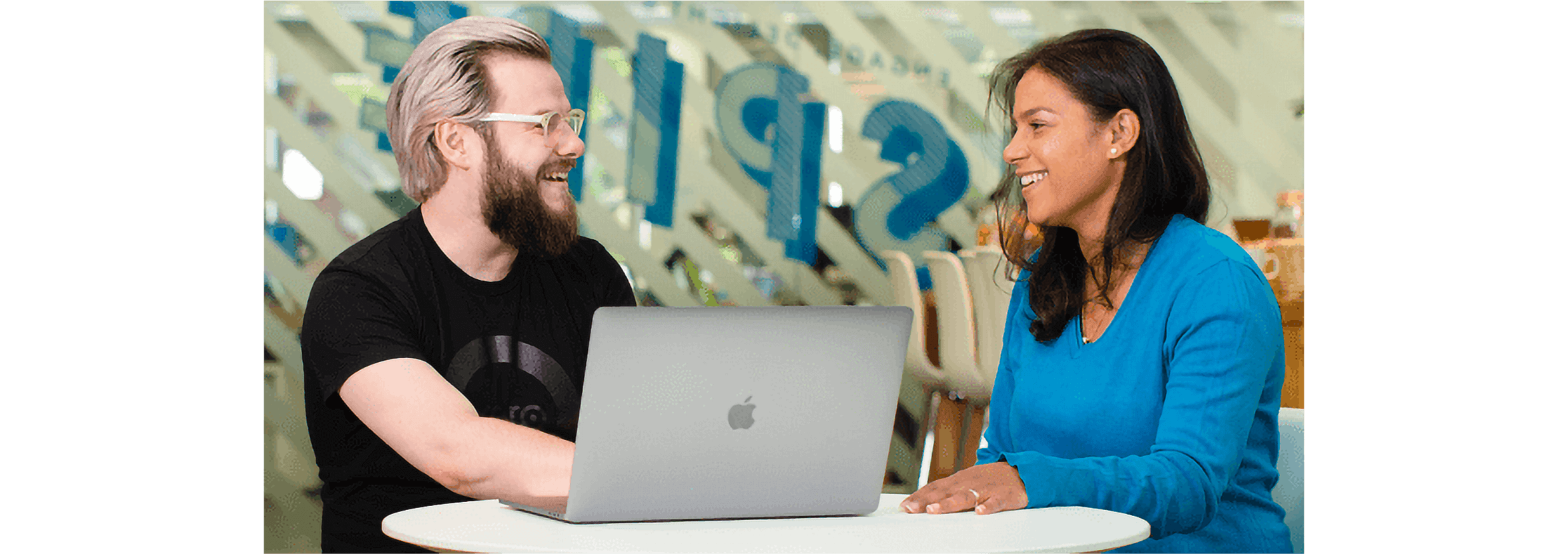 An accountant and client sit at a table setting up Xero accounts on a laptop.