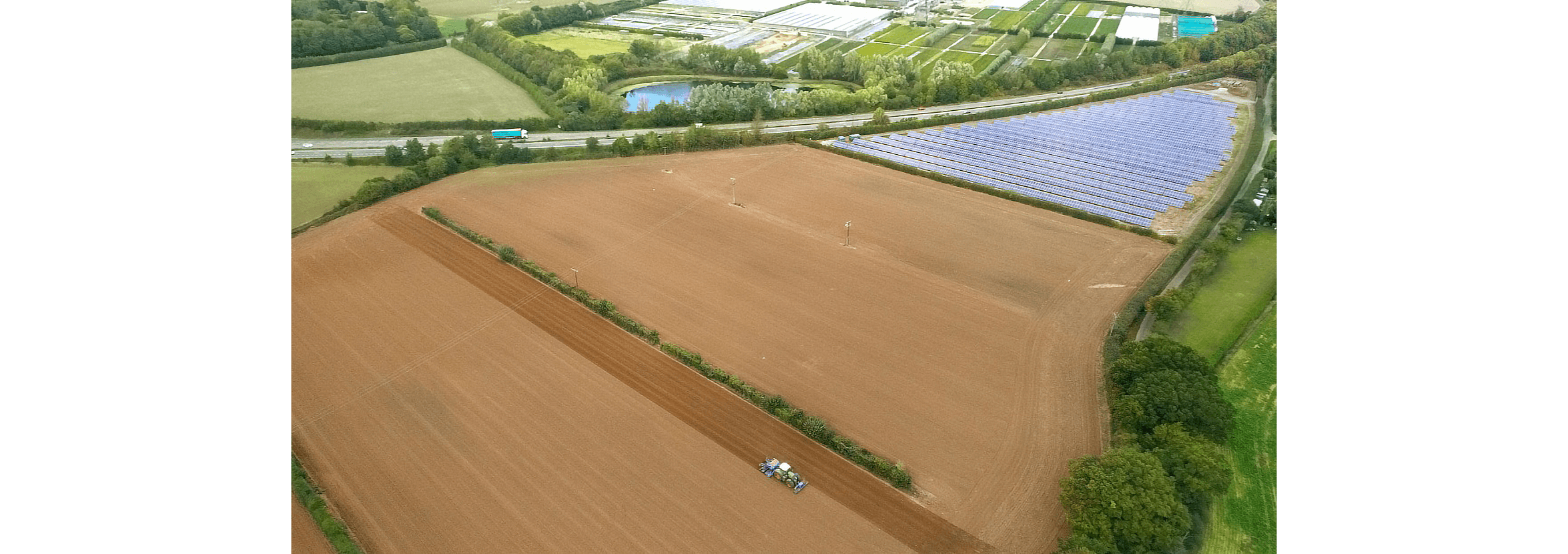 Aerial view of a tractor working a ploughed field.