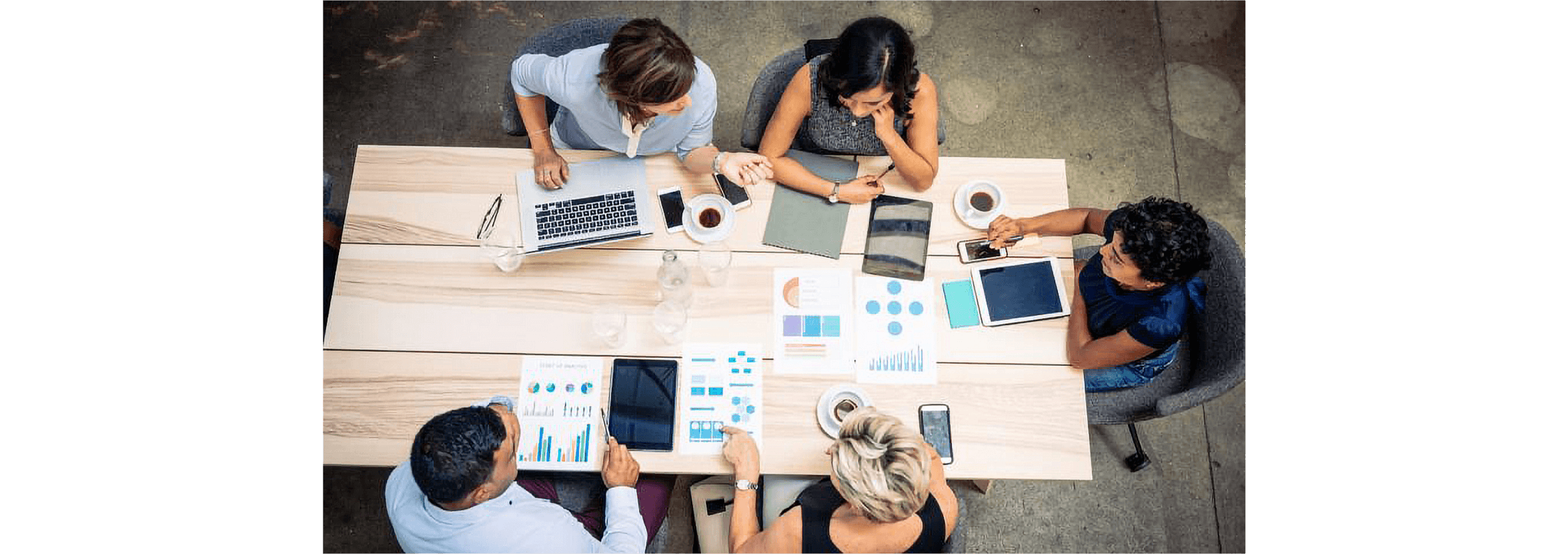 A small business team sits around a table with their accountant, all working from a tablet, laptop or mobile device.