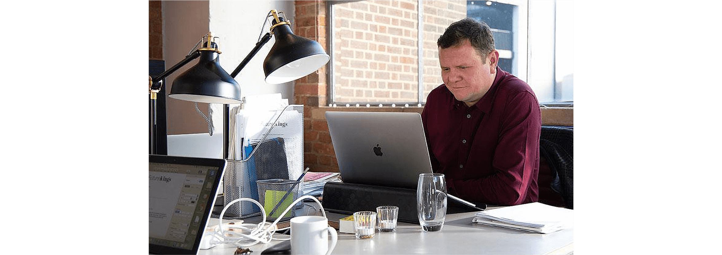 A small business owner works at their laptop in their office.