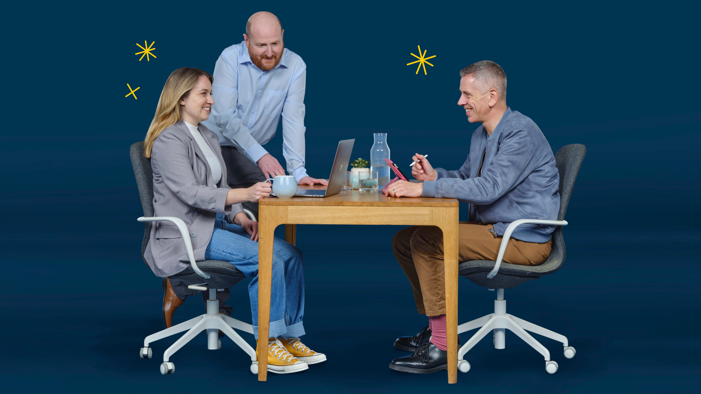 3 partners discuss cybersecurity at a desk.